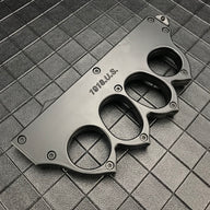 A close-up of a closed black knuckle duster OTF knife, showing the engraved "1918 U.S." text and screw details on a dark grid background.