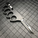 An open 1918 U.S. style black knuckle duster OTF knife with a silver blade, showing the silver pocket clip on the back of the handle, displayed on a dark grid background.