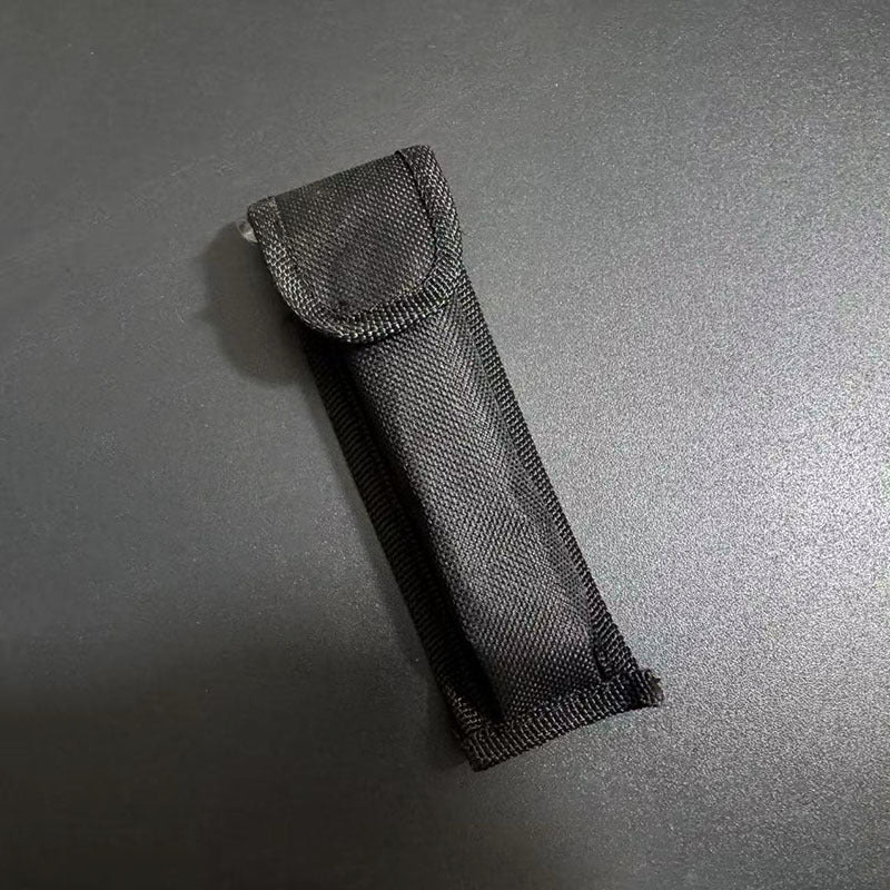 A close-up of a black nylon carrying sheath designed for a balisong butterfly knife, displayed on a dark background.
