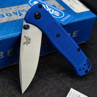 An open Benchmade folding knife with a blue handle, silver blade, and blue thumb stud, displayed with its blue box.