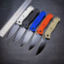 Five Benchmade folding knives in different colors placed next to a metal ruler on a dark textured surface for size comparison.
