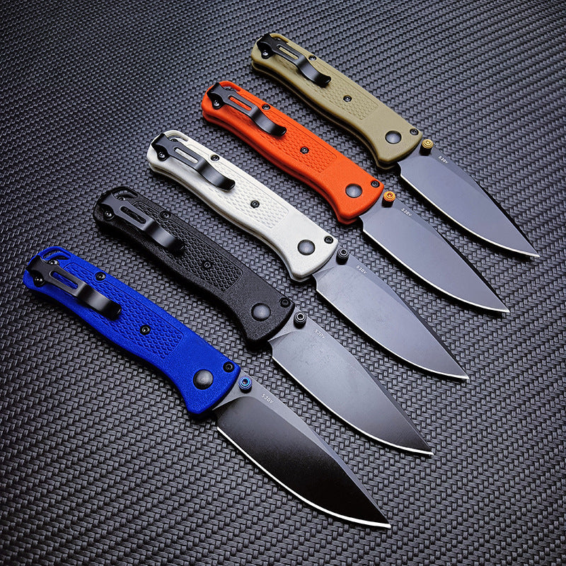 Five Benchmade folding knives shown from the back side, highlighting the black pocket clips on blue, black, white, orange, and tan handles.