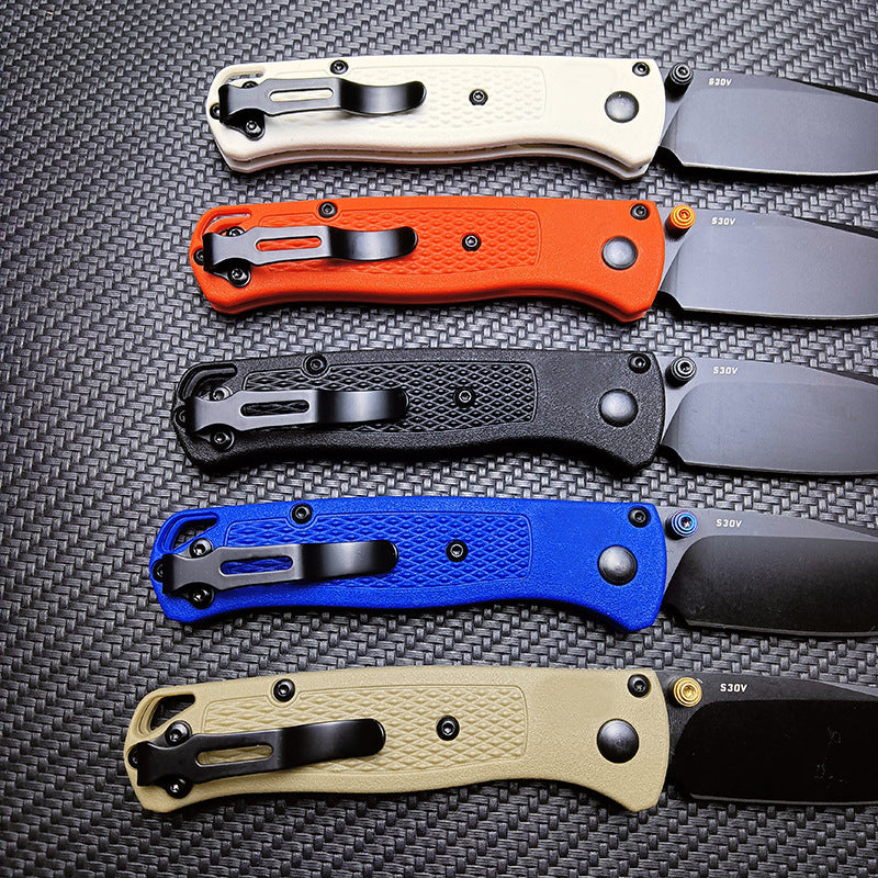 The back side of five Benchmade folding knives, showing the black pocket clips and S30V steel markings on the blades.