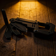 A black EDC carabiner multi-tool with deployed blades, a bottle opener, and a detachable bit holder, illuminated by a warm spotlight on a rustic wooden surface.