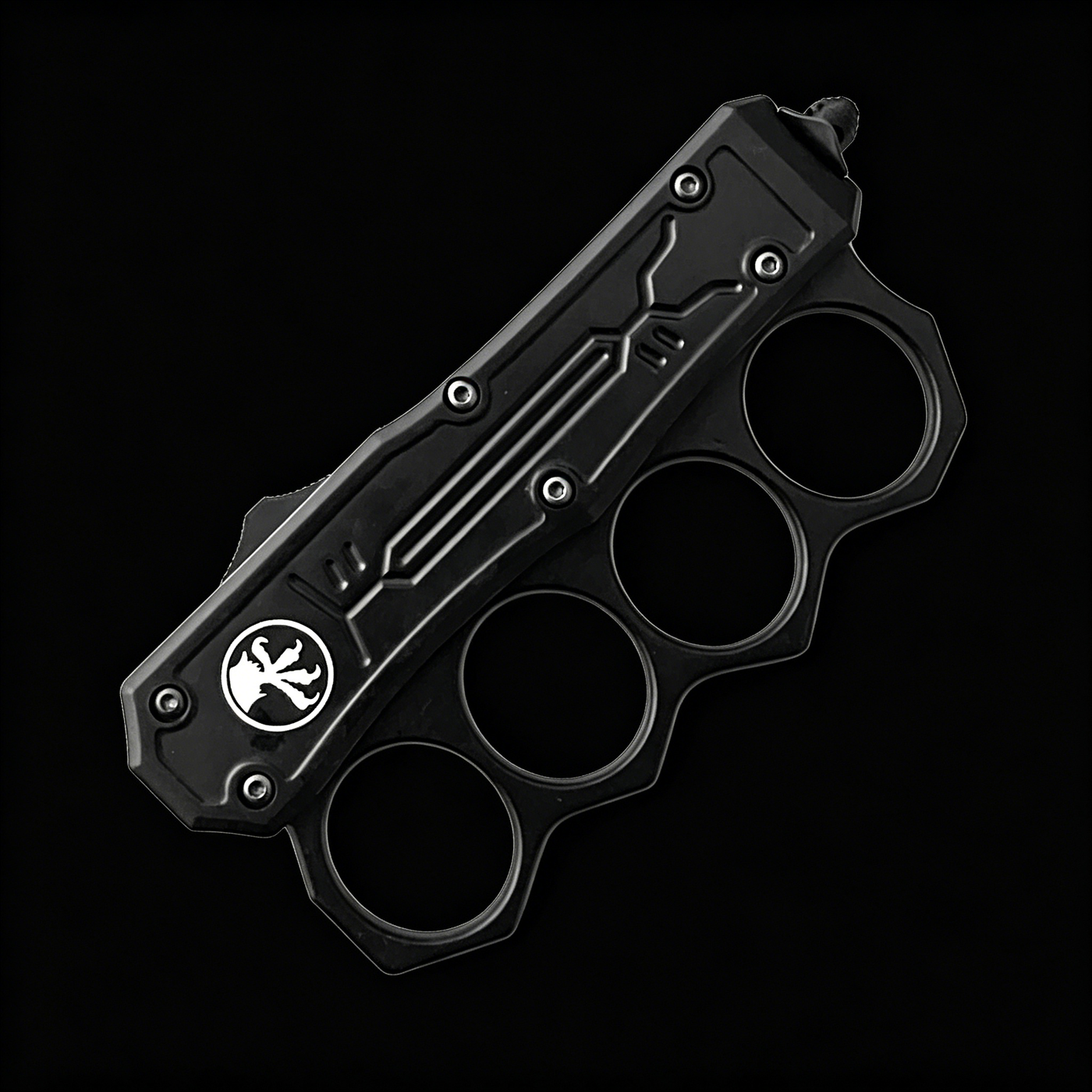 A closed black OTF knife with a knuckle duster handle, white logo, and blue screws, displayed on a black background.