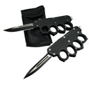 Two open black OTF knives with knuckle duster handles and black blades, one plain edge and one serrated, displayed next to a black nylon sheath on a white background.