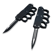 Two open black knuckle duster OTF knives, one plain edge and one serrated, displayed on a white background for product clarity.