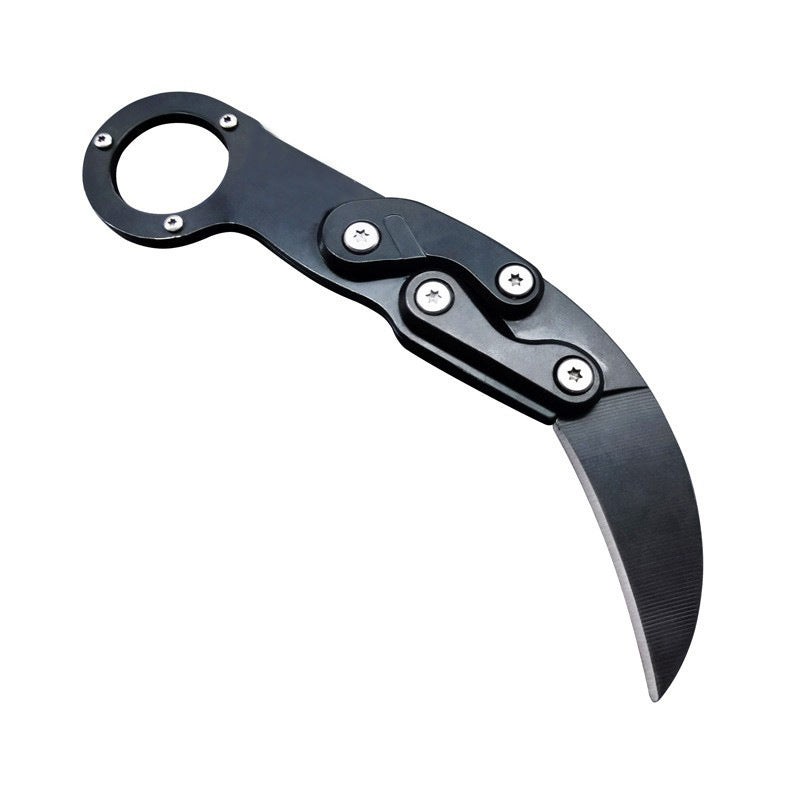 An open black mechanical folding karambit knife with a finger ring handle and articulated arms, displayed on a white background.