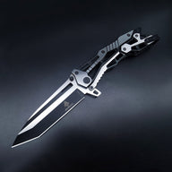 An open tactical folding knife with a black Tanto blade and a two-tone black and silver skeletonized handle, displayed on a dark background.