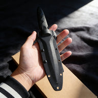 Hand-held black tactical fixed blade knife display, featuring a comfortable Kydex sheath grip and protective guard design to prevent the hand from slipping toward the blade. Ideal for tactical defense and outdoor survival use.