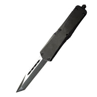 A black OTF knife with a tanto blade and black hardware, displayed on a white background.