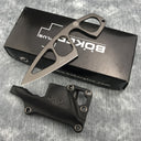 A Böker Plus skeletonized fixed blade knife displayed over its black packaging box and leather sheath on a denim-textured surface.