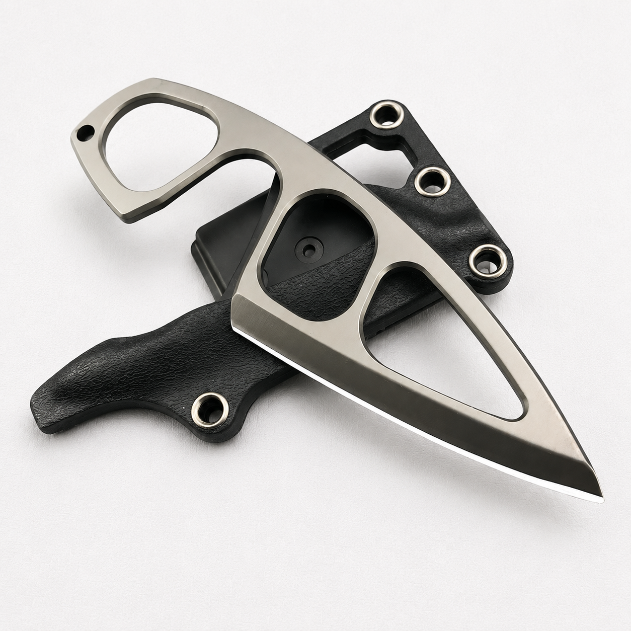 A Böker Plus skeletonized fixed blade knife with a finger ring and hollow cutouts, displayed on its black leather and polymer sheath against a white background.