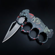 An angled view of an open BROWNING knuckle duster folding knife, highlighting the intricate skull and red details on the handle and the blade cutout design.