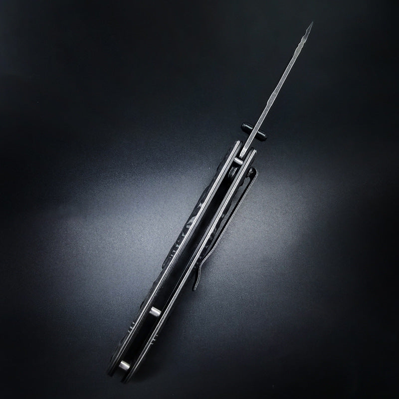 A closed EDC folding knife with a dark handle, silver liners, a pocket clip, and a pointed glass breaker tip, displayed on a dark background.