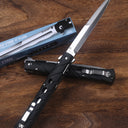 An open and a closed Cold Steel Ti-Lite folding knife with black handles, displayed next to a blue packaging box on a wooden desk.
