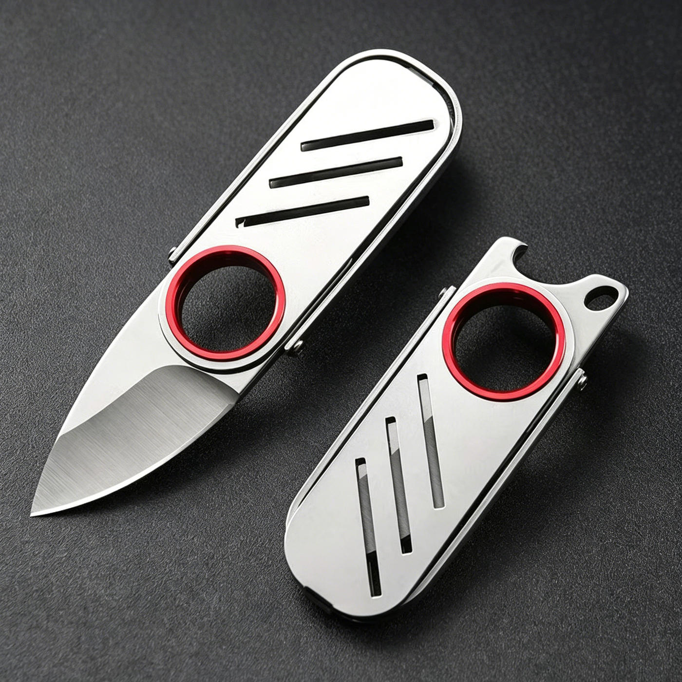 An open and a closed EDC keychain folding knife with a silver stainless steel body and red ring, displayed on a dark textured surface.