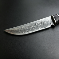 Close-up of Damascus Steel Blade – Showcasing the unique folded forging patterns (water or cloud patterns) and razor-sharp edge.