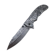 An open folding knife with intricate engravings of a deer, a wolf, and mountain landscapes on the blade and handle, displayed on a white background.