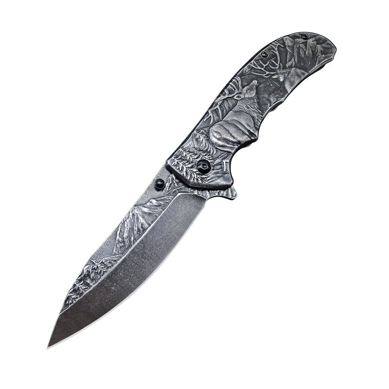 An open folding knife with intricate engravings of a deer, a wolf, and mountain landscapes on the blade and handle, displayed on a white background.