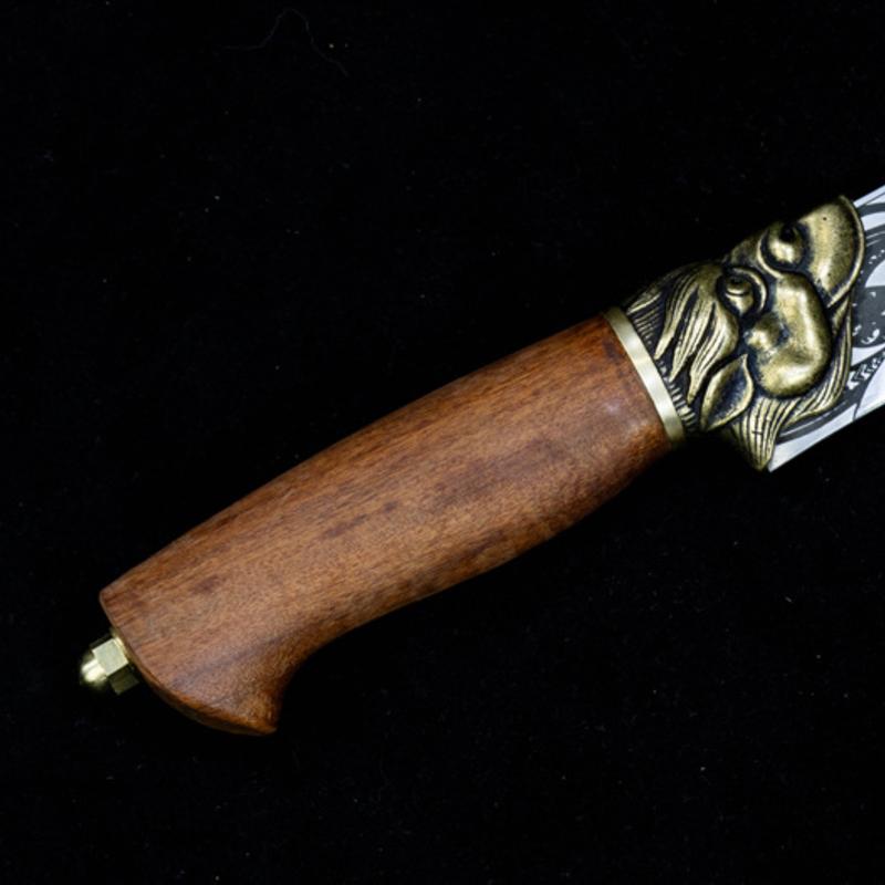 A side profile close-up of the wooden handle and brass animal head guard of a custom engraved knife, displayed on a dark background.