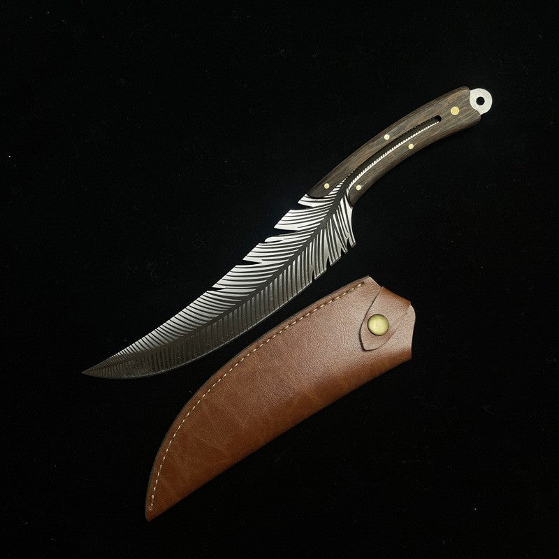 A custom fixed blade knife with a silver feather-engraved blade and a dark wood handle with brass pins, displayed next to its brown leather sheath with a brass snap button, on a black background.