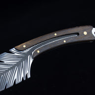 A close-up of the dark wood handle and silver blade with intricate feather-like serrations and brass pin accents.