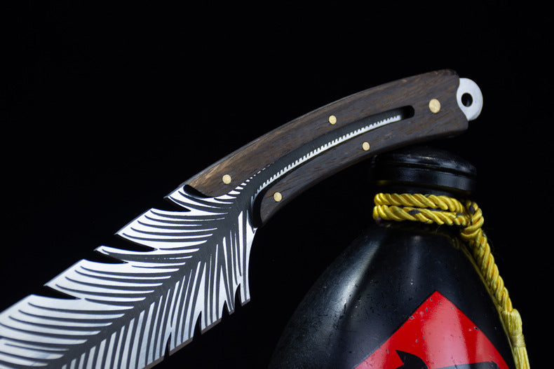 A close-up of the feather blade knife resting its handle on top of the black liquor gourd, highlighting the blade and handle design.