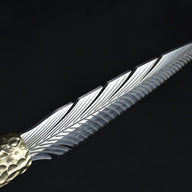 A side profile view of a silver fixed blade knife, showcasing the detailed feather engraving and the hammered brass bolster.