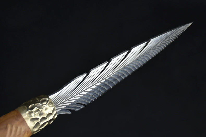 A side profile view of a silver fixed blade knife, showcasing the detailed feather engraving and the hammered brass bolster.