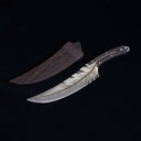 A custom fixed blade knife with a silver feather-patterned blade and dark wood handle, displayed next to its dark wooden sheath against a black background.