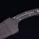 A close-up of the dark wooden sheath and handle, highlighting the matching wood grain, brass pins, and wrapped cord detail.