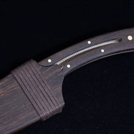 A close-up of the dark wooden sheath and handle, highlighting the matching wood grain, brass pins, and wrapped cord detail.