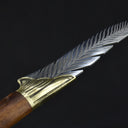 A detailed close-up of the silver blade's spine, showcasing the precise feather texture engraving of the knife.