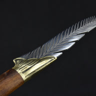 A detailed close-up of the silver blade's spine, showcasing the precise feather texture engraving of the knife.