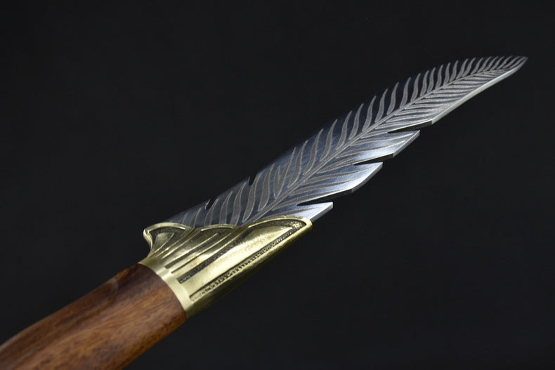 A detailed close-up of the silver blade's spine, showcasing the precise feather texture engraving of the knife.
