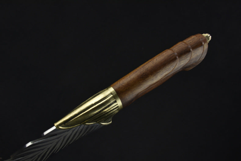 A close-up of the rear end of the wooden handle, featuring a decorative brass pommel on a feather blade knife.