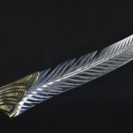 A close-up highlighting the curved edge and layered feather pattern engraving on the silver blade of a fixed knife.