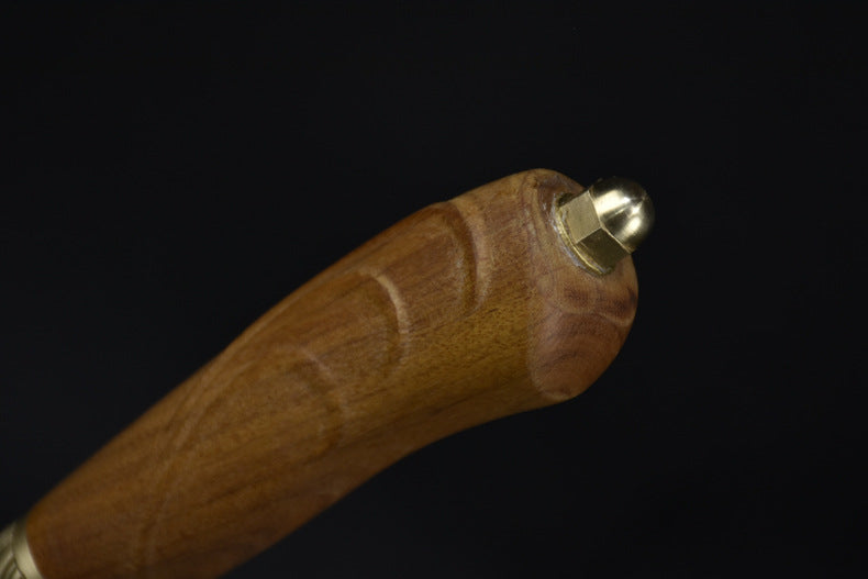 A close-up of the wooden handle's butt end, featuring a brass nut and ball end cap, displayed against a dark background.
