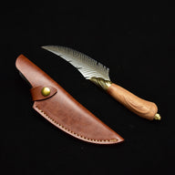 An engraved feather-blade fixed knife displayed with its brown leather sheath and brass snap button on a dark background.
