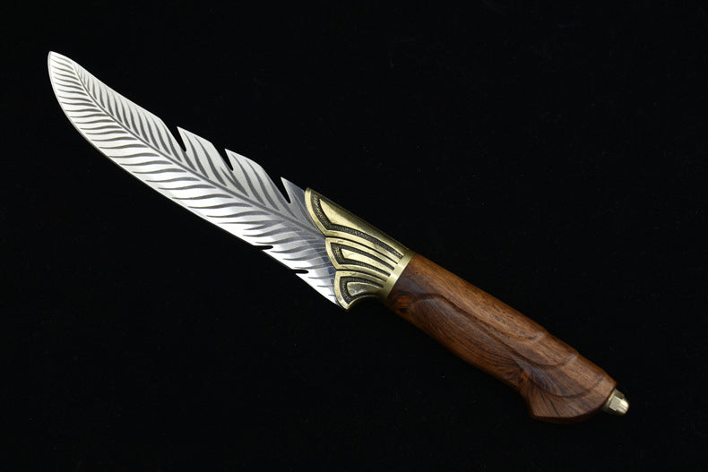 A close-up of the wooden handle and textured brass bolster of a feather-blade fixed knife, displayed on a black background.