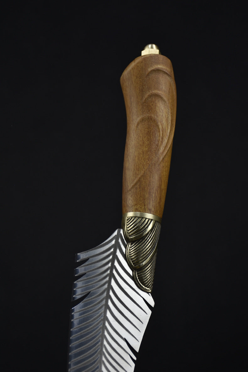 A close-up view of the carved wooden handle and brass pommel of a custom fixed blade knife, showcasing the natural grain and brass hardware details.