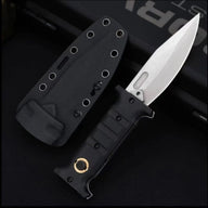 An open folding knife with a black handle featuring a gold pivot and a silver blade with a fuller, displayed next to a black hard sheath on a dark background.