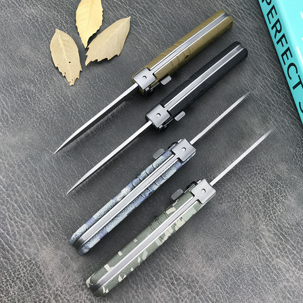 Four closed folding knives arranged vertically showing their spines and blade profiles, placed next to dried yellow leaves on a leather texture.
