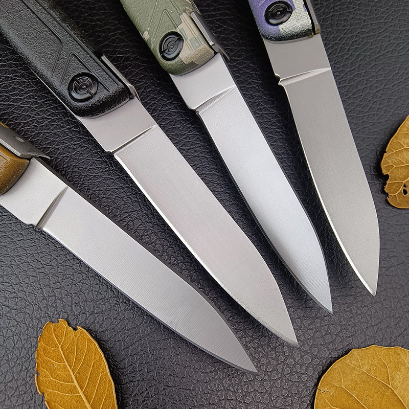 A macro shot of four folding knife blades showing the fine grind lines, sharp tips, and metallic finish.