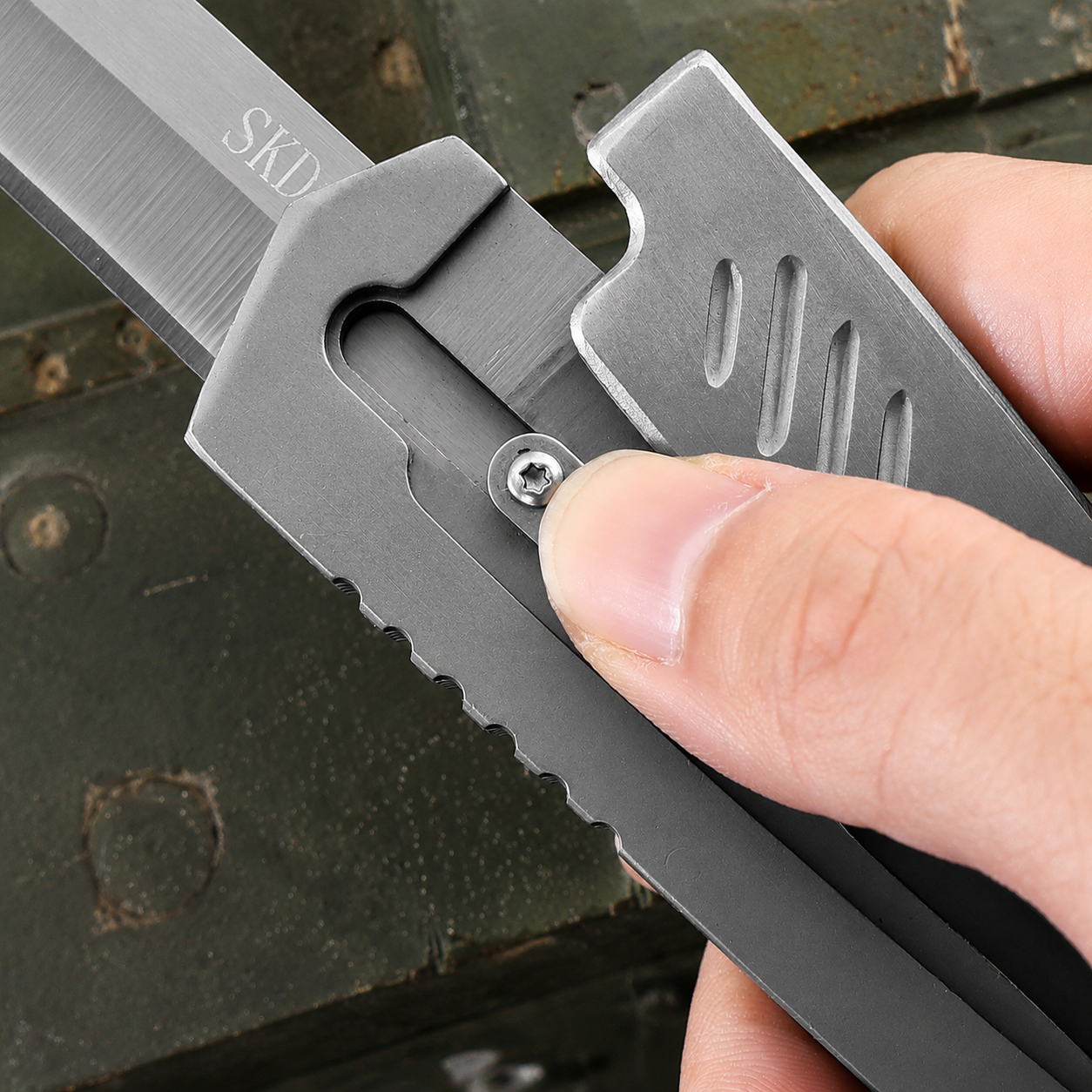 Close-up of the full-metal gravity folding knife’s mechanical structure, with the thumb sliding along the guide rail groove to use inertia for deploying the blade, delivering smooth operation and a strong mechanical feel.