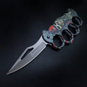 An open knuckle duster folding knife with a grey textured skull graphic handle and a silver blade featuring a cutout and the BROWNING logo, displayed on a dark background.