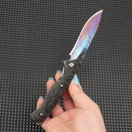 Close-up of the fully opened folding knife, featuring a stunning colorful Damascus blade paired with a dark textured handle, showcasing premium EDC knife aesthetics.