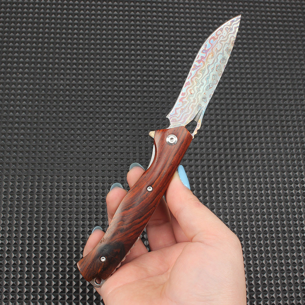 Close-up of this redwood handle folding knife in the open position, showing the visual contrast between the colorful Damascus blade and the classic redwood handle, showcasing the premium EDC knife craftsmanship.