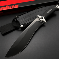 A Kershaw fixed blade knife with a full black blade and textured handle, featuring a silver guard, displayed next to its black molded sheath and red and black packaging box on a dark background.